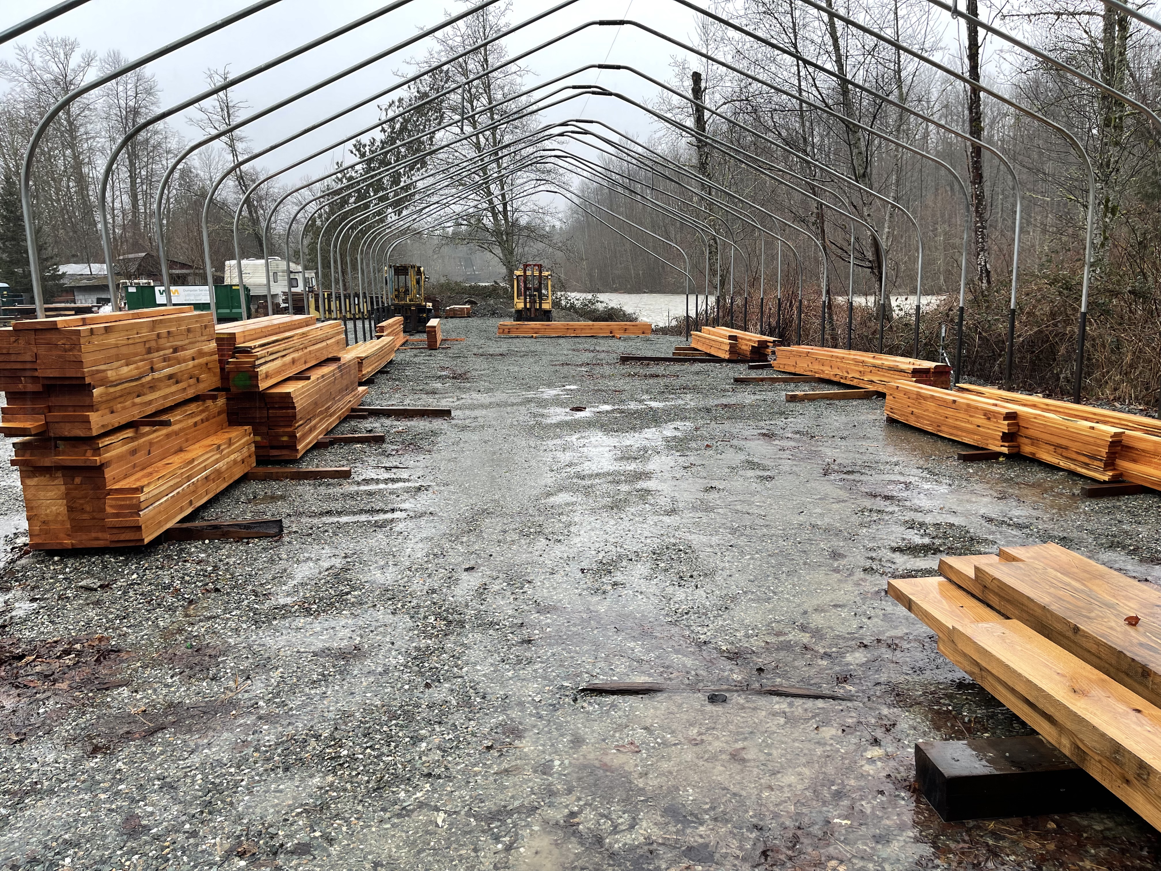 Rows of freshly milled Douglas Fir timbers stacked under the covered drying structure at the Arlington mill