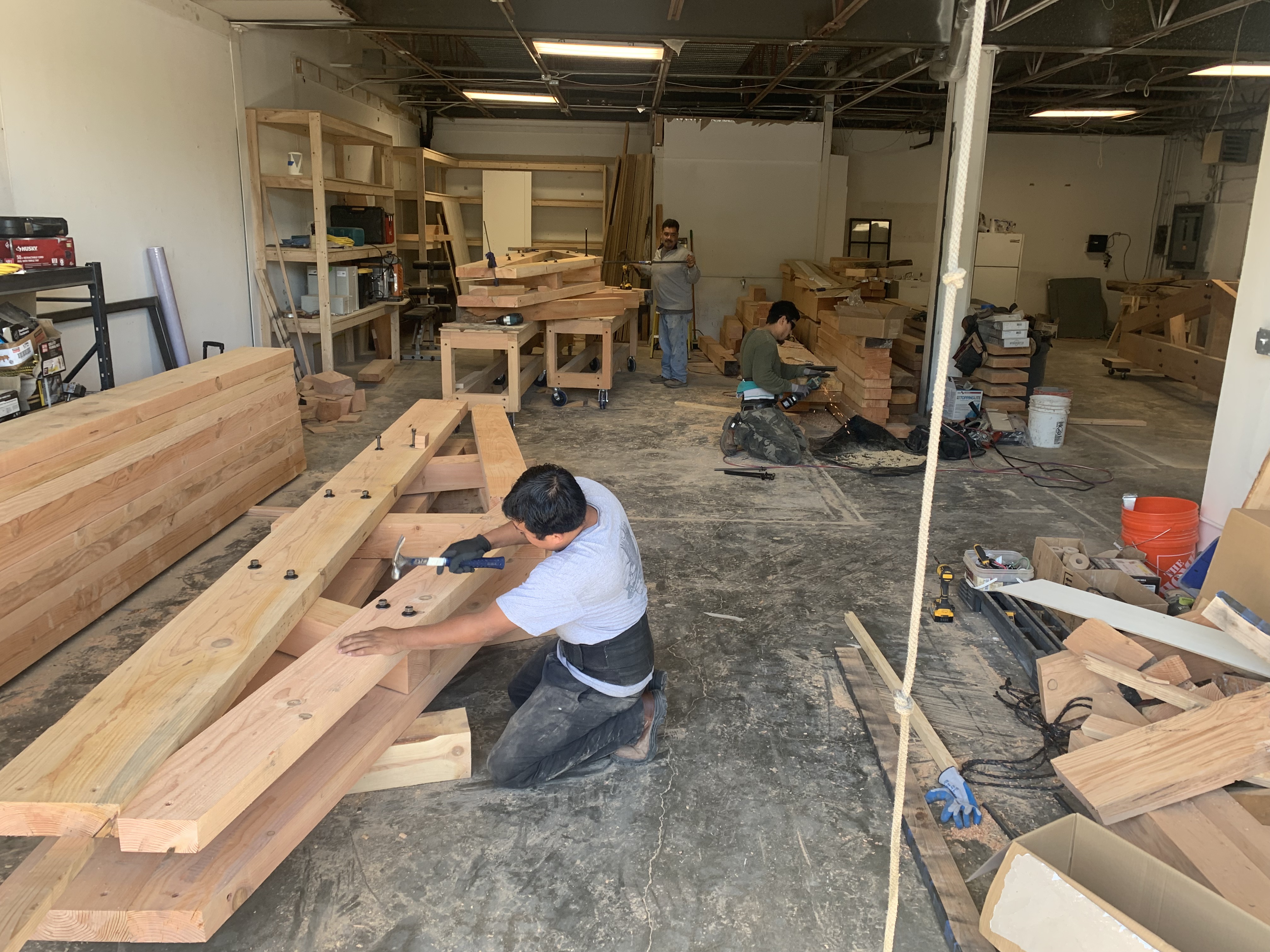 Crew cutting and fitting Douglas Fir timber frame joinery on the shop floor