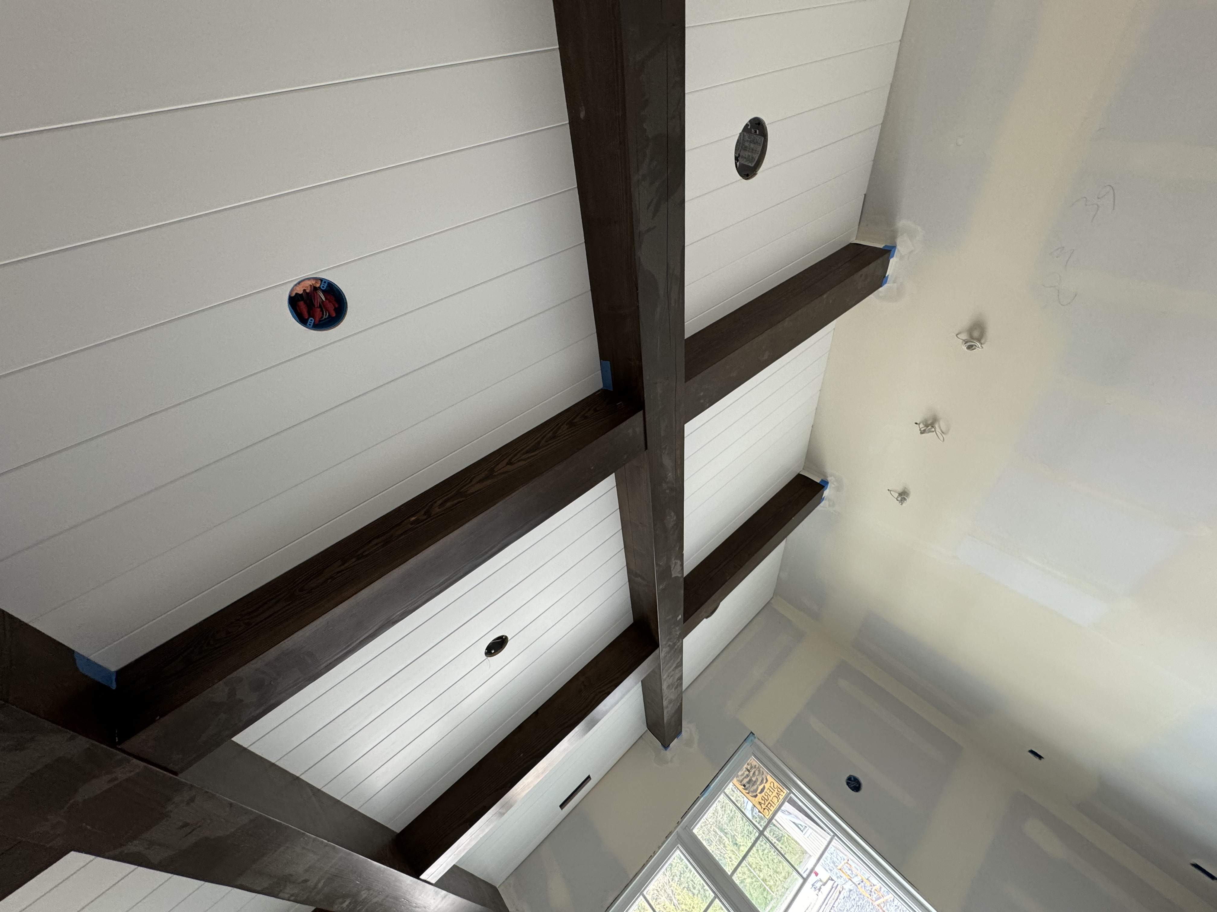Dark stained timber beams on shiplap ceiling interior