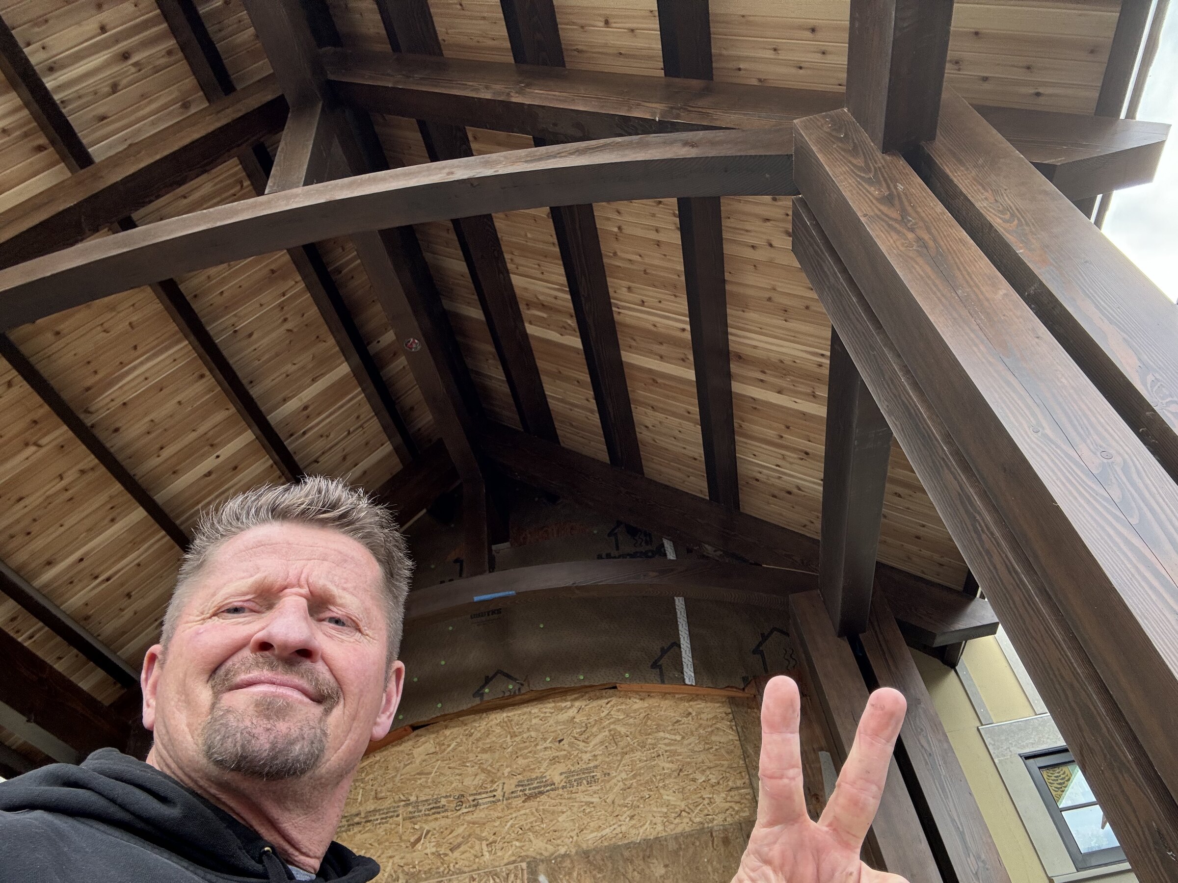 Shawn Roten under one of his completed timber frames